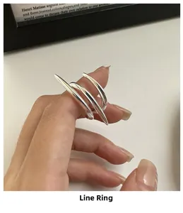 Close-up of minimalist 925 sterling silver multi-line wrap ring on model finger