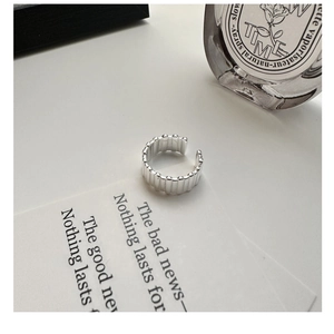 Macro detail of silver geometric striped ring on elegant white lifestyle background