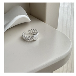 Macro detail of S925 sterling silver heart ring with engraved letters and chain band