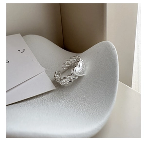 Close-up of S925 silver heart ring with Give Me Love engraving and braided chain texture