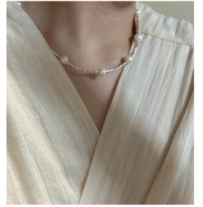 Détail d'un collier en argent S925 et perles d'eau douce porté avec élégance par un mannequin
