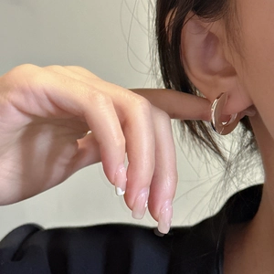 Polished S925 sterling silver geometric hoop earrings worn by model in a minimalist style