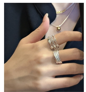 Detail of layered 925 silver rings featuring open chain link and textured wire design
