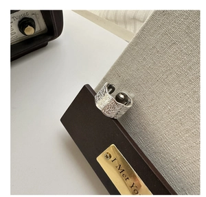 Macro detail of a wide S925 sterling silver ring with intricate vintage floral engravings
