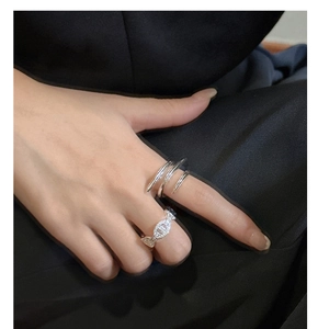 Close-up of a 925 silver multi-layer spiral ring and hollow chain ring on fingers