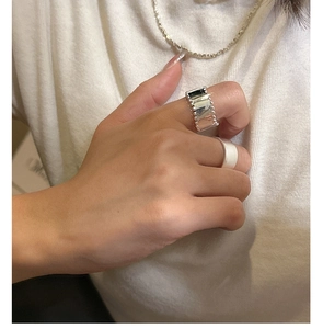 Detail of silver beaded edge wide ring and minimalist smooth ring on model hand