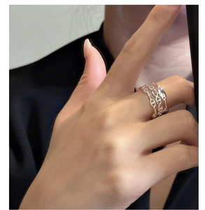Close-up of three-layered sterling silver interlocking pig nose ring on finger
