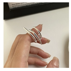 Detail of 925 sterling silver layered cross ring on hand with modern polished finish
