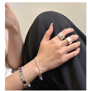 Close-up of S925 sterling silver beaded bracelet and minimalist rings on model hand