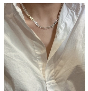 Dettaglio collana in argento S925 a maglia a naso di maiale su camicia bianca
