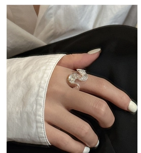Detail of wavy S925 sterling silver ring with liquid metal texture on model's finger