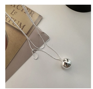 Détail macro d'une chaîne à billes en argent 925 poli avec pendentif sphérique élégant