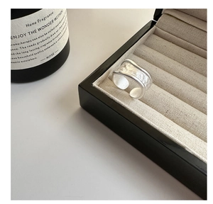 Macro shot of minimalist matte silver wide open ring inside a jewelry display box