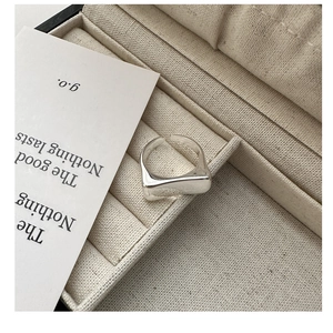 Vue macro de la bague carrée minimaliste en argent S925 avec finition polie sur tissu