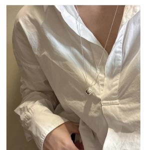 Vue détaillée d'un collier avec pendentif boule en argent 925 porté par un mannequin