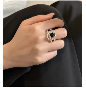 Detail of silver textured ring featuring a black onyx bead in a fluid metal frame