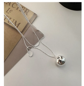 Vue macro de la chaîne à billes en argent 925 avec pendentif sphérique poli miroir