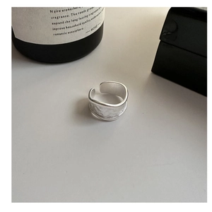 Detail showing the matte silver wide ring with hand-hammered texture and adjustable band