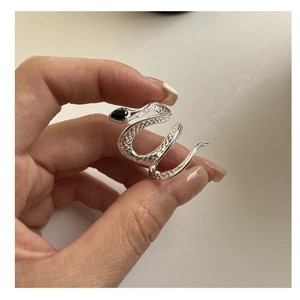 Macro shot of silver snake ring featuring detailed scales and a black pear-cut gemstone
