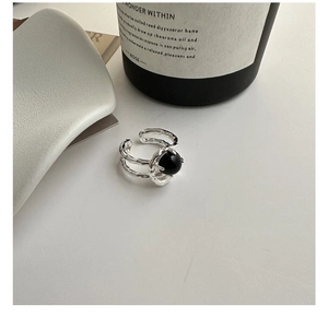 Macro detail of S925 silver ring featuring black agate and irregular lava texture finish