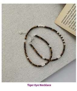 Détail de perles d'oeil de tigre avec breloques en argent S925 sur un collier