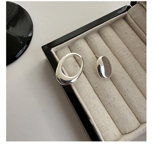 Macro detail of S925 silver asymmetric earrings with high-gloss liquid metal finish