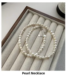 Detail of S925 silver irregular pearl necklace with heart charm in beige jewelry box
