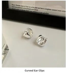 Minimalist S925 sterling silver curved hoop earrings on a clean artistic backdrop