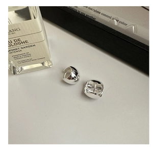 Macro shot of silver-toned hoop earrings with high-polish finish on a clean white surface