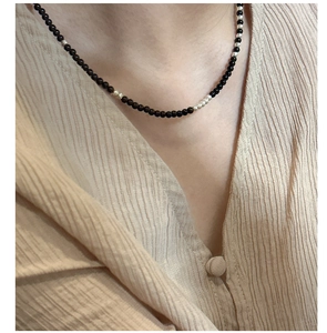 Macro shot of minimalist S925 silver and black onyx beaded choker necklace on model