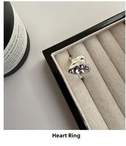 Macro shot of silver hammer-textured heart ring displayed in a black jewelry box