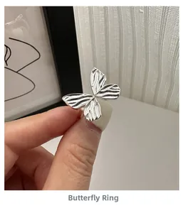 Macro shot of S925 sterling silver bow ring with detailed brushed texture on butterfly wings