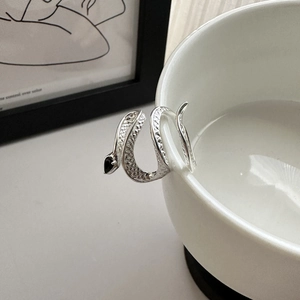 S925 sterling silver snake ring with black zircon stone on white porcelain bowl