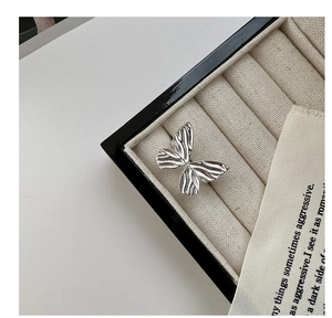 Detailed close-up of S925 sterling silver bow ring with textured wings on jewelry box