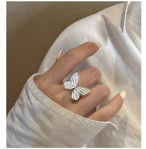 Detailed close-up of S925 sterling silver bow ring with brushed metal wing texture