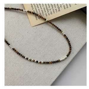 Détail macro du collier en perles d'oeil de tigre fait main avec accents argentés