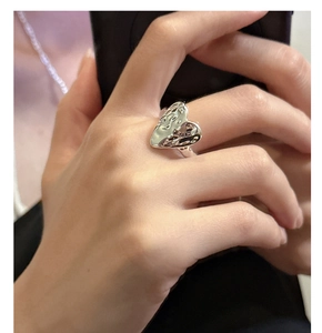 Macro detail of S925 silver heart ring featuring unique hammered lava texture on hand