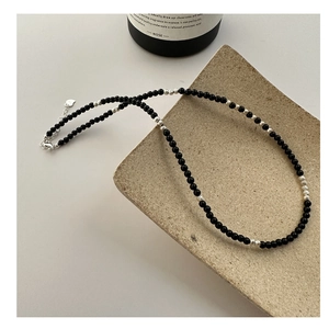 Macro shot of S925 silver beaded necklace with black agate and heart pendant clasp