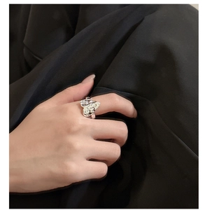 Detailed view of liquid metal heart ring with hammered texture on black fabric