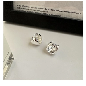 Close-up of polished S925 sterling silver hoop earrings on a clean white surface