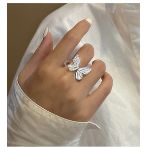 Detailed close-up of S925 silver bow ring with 3D pleated texture worn on finger