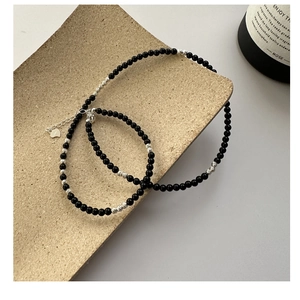Detail of S925 silver necklace with black agate beads and heart-shaped pendant