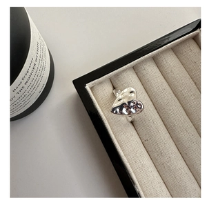 Detail of S925 sterling silver hammered heart ring displayed in a beige jewelry box