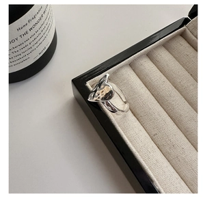 Detail of silver hammered heart ring displayed in a black and white jewelry box