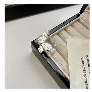 Macro shot of S925 sterling silver bow ring featuring detailed textured wings on velvet