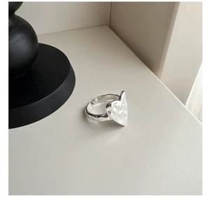 Macro view of S925 sterling silver heart ring featuring hammered texture and open band