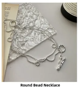 Gros plan détaillé du collier en perles d'argent S925 avec fermoir OT et pendentif en T