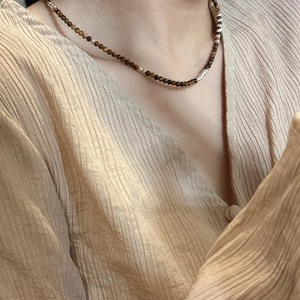 Collier minimaliste en argent S925 avec perles d'oeil de tigre sur le cou d'un modèle