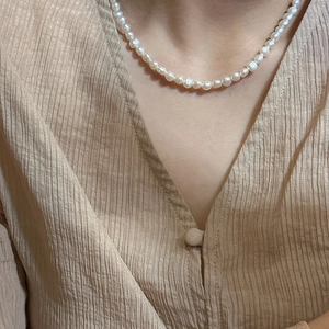 Elegant S925 silver necklace featuring irregular natural white pearls on a model