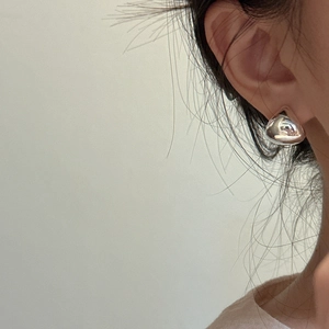 S925 sterling silver water drop earring with a sleek mirror finish on a female model